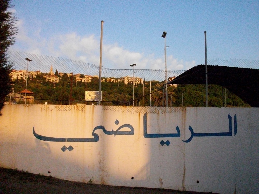sports field with "al-riyadi" lettering