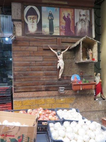 Jesus and saints images and statues at a vegetable stand